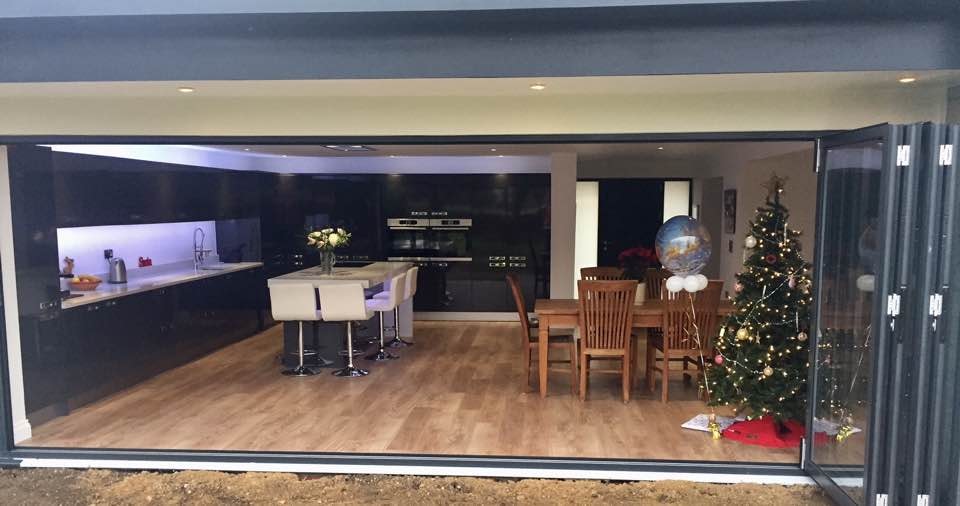 Completed extension — bifold doors opening onto garden, kitchen and dining area